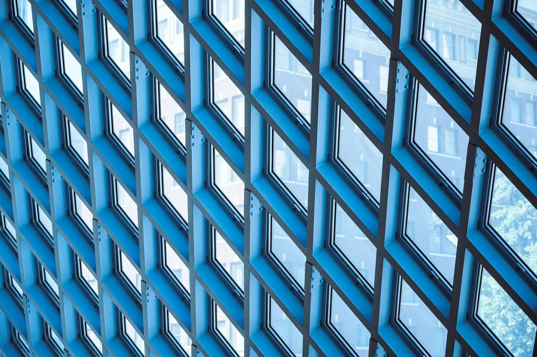 Geometric pattern of blue-tinted windows in a modern architectural structure.