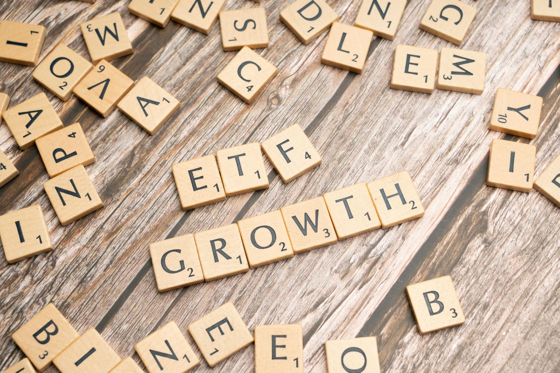Scrabble tiles spelling 'ETF GROWTH' on wooden surface