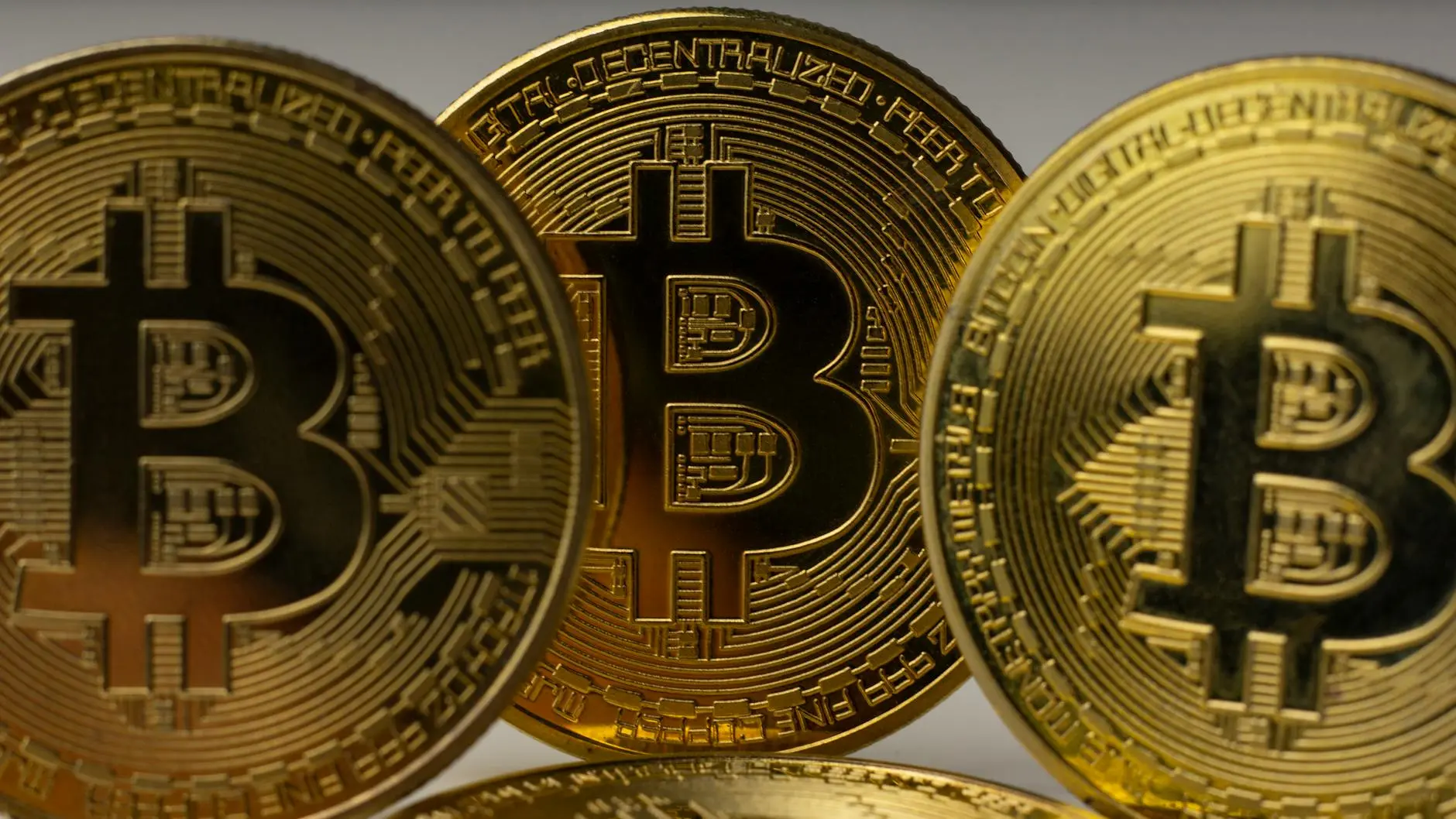 Close-up of gold Bitcoin coins showcasing intricate designs.