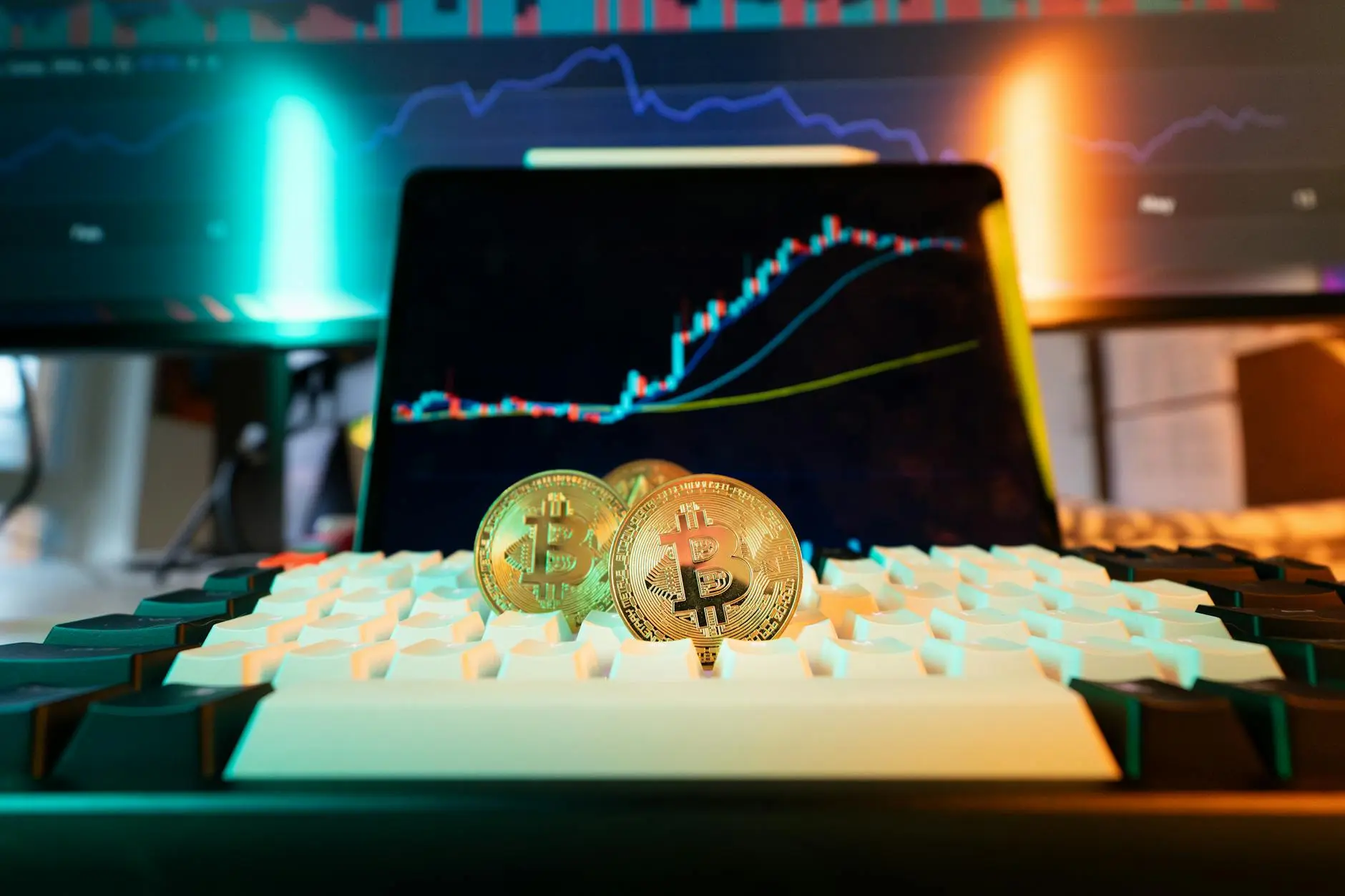 Bitcoin coins in front of a tablet displaying a bullish price chart.