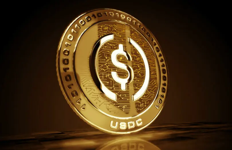3D rendering of a gold USDC coin with digital patterns and a dollar sign.