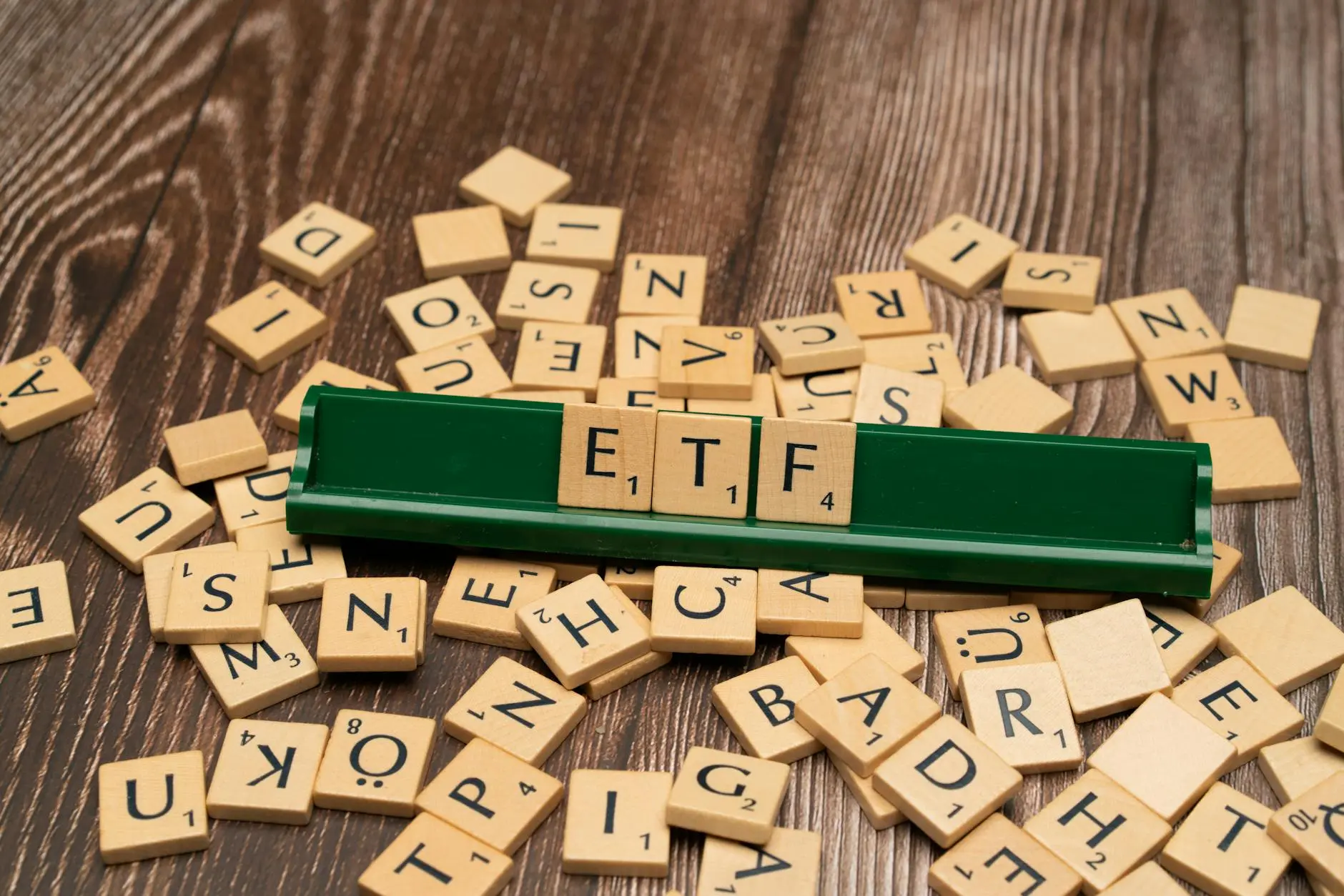 Scrabble tiles scattered on a wooden table, with 'ETF' prominently displayed.