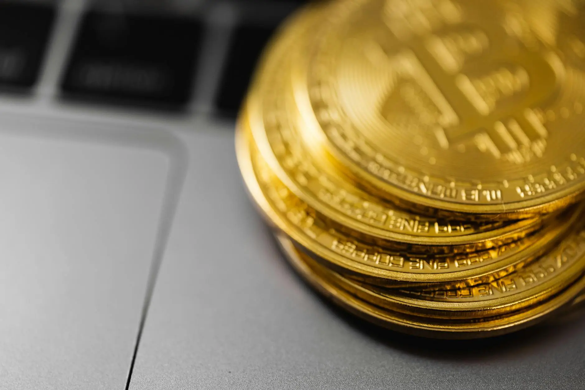 Stack of Bitcoin coins on a laptop keyboard background.