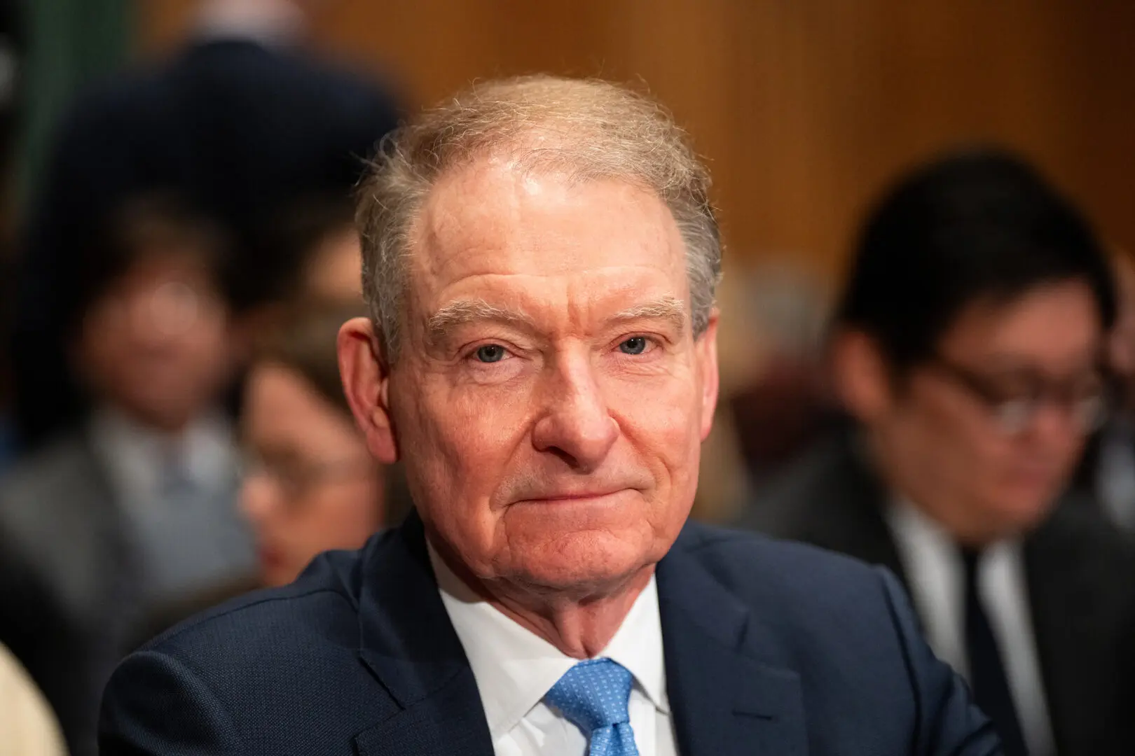 Close-up portrait of Paul Atkins wearing a navy blue suit and light blue tie.