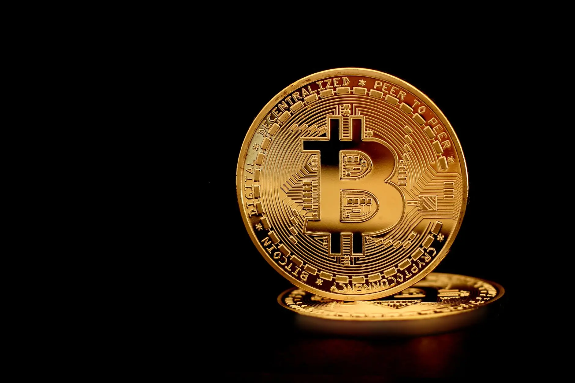 Close-up of gold Bitcoin coins on a black background