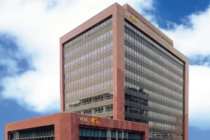 The KB Financial Group headquarters building in Seoul, featuring a red facade and the KB logo on top.