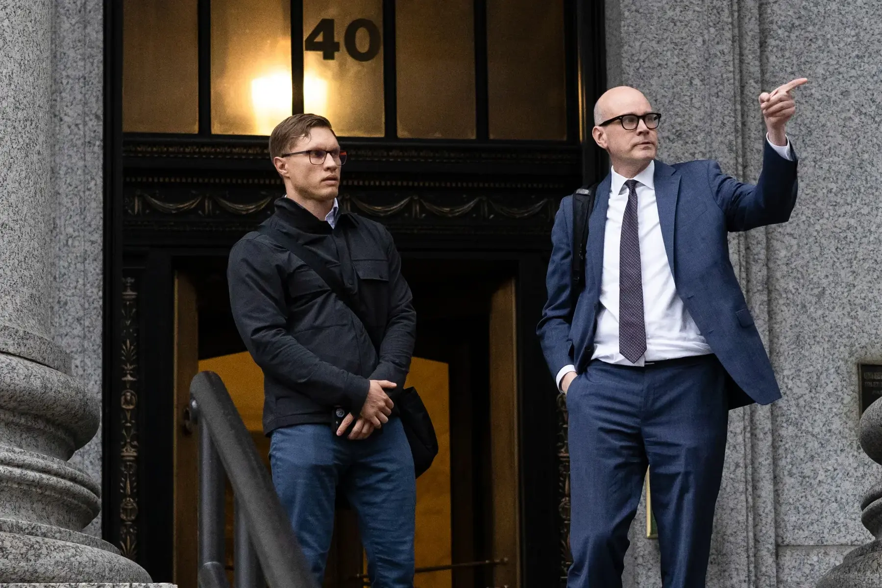 Roman Storm and his lawyer standing in front of a courthouse entrance.