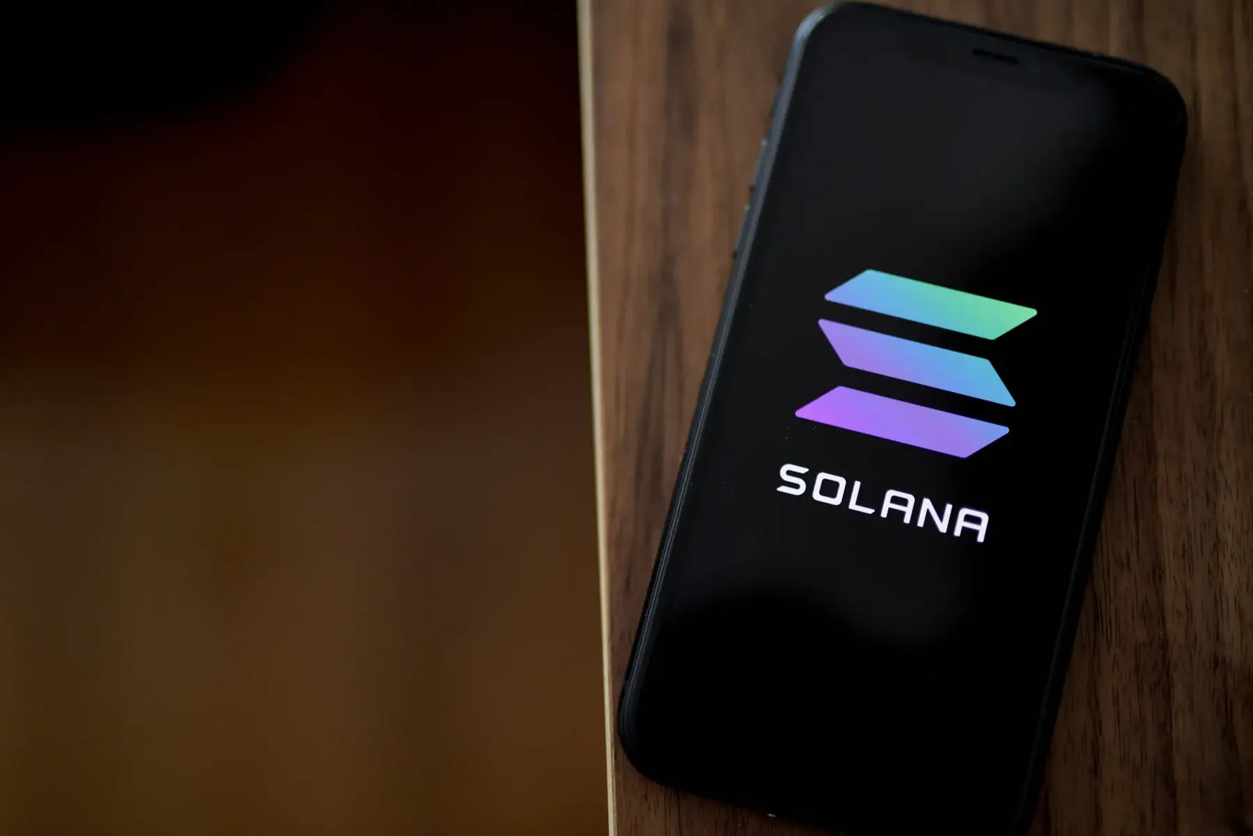 Smartphone screen displaying the Solana logo and text on a black background