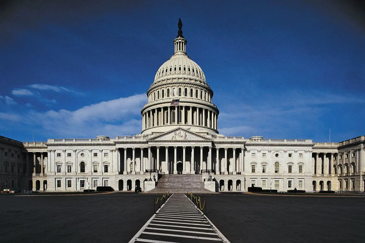 Wide shot of the United States Capitol building in Washington D.C. under a clear blue sky