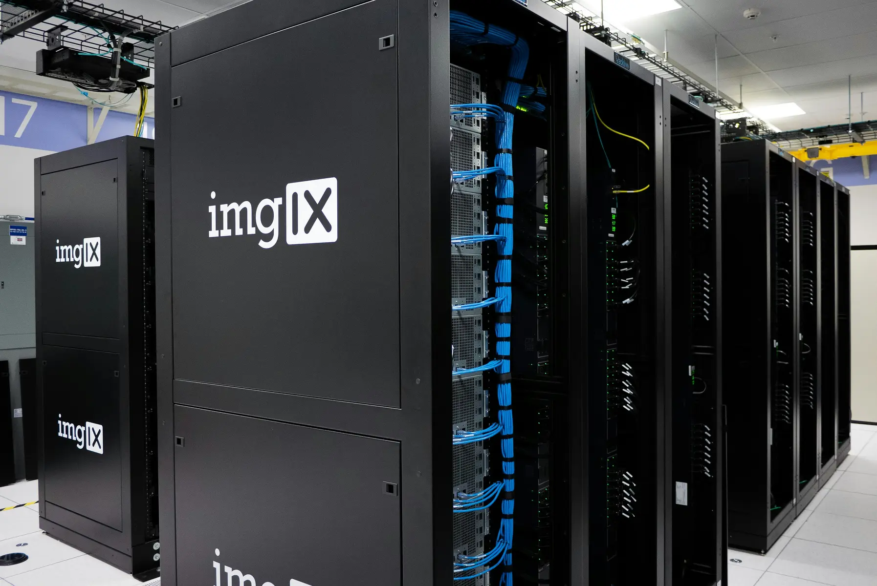 Schwarze Server-Racks mit blauen Kabelverbindungen in einem Rechenzentrum.