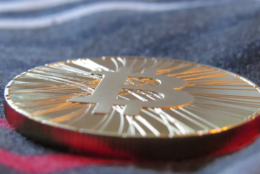 Eine goldfarbene physische Bitcoin-Münze in Nahaufnahme.