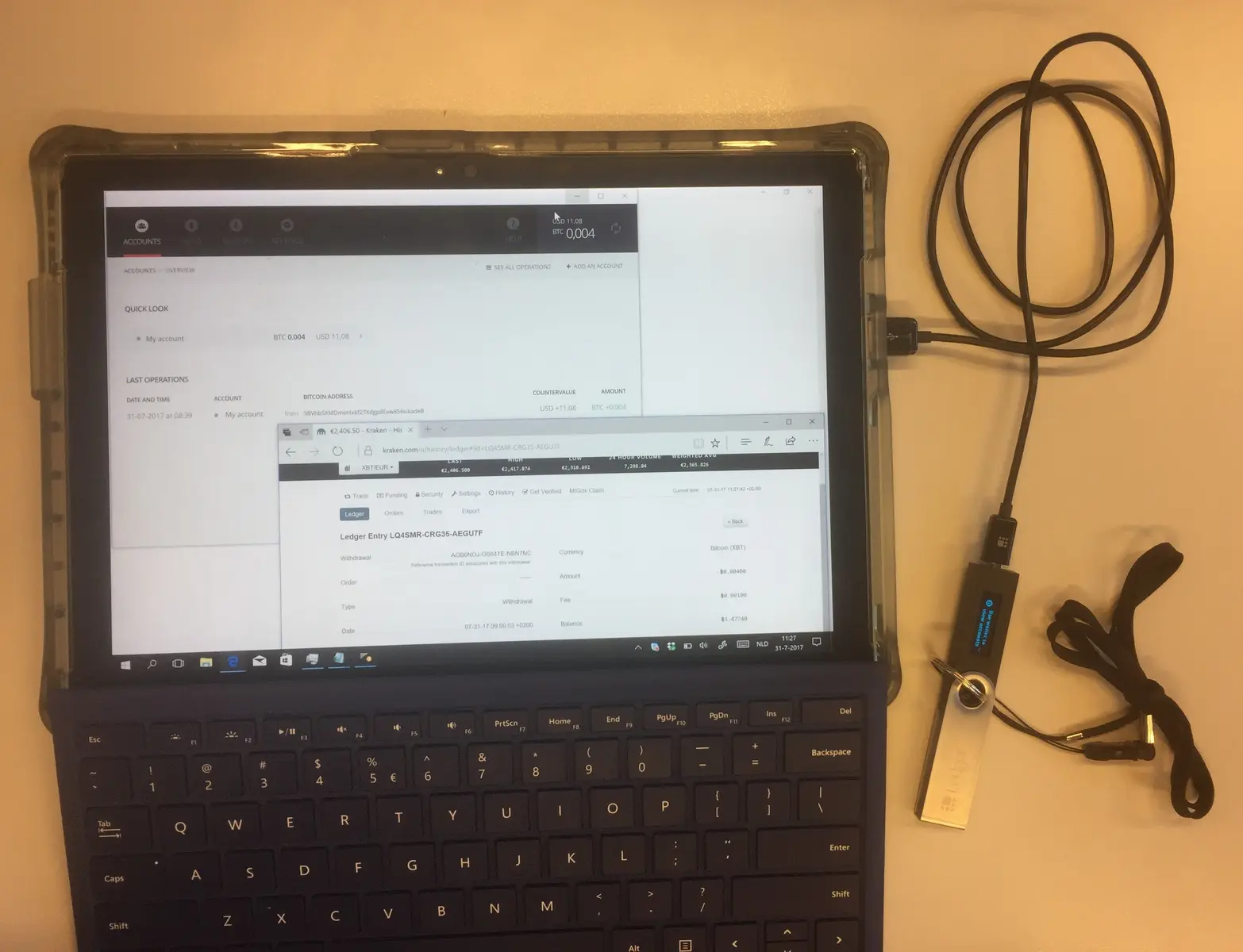 Ein Tablet zeigt die Benutzeroberfläche der Kryptobörse Kraken neben einer Hardware-Wallet.
