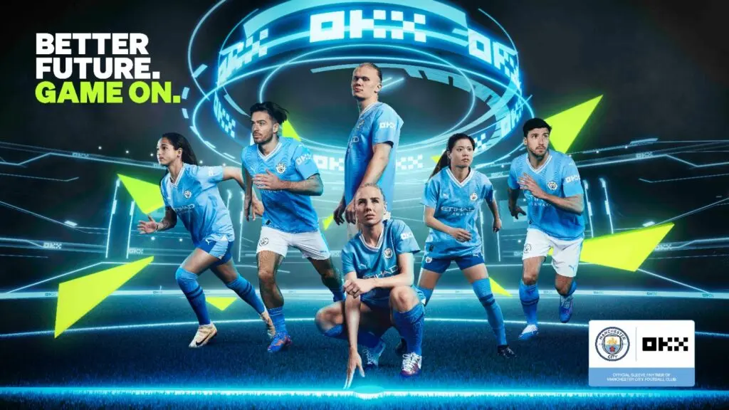 Manchester City players in light blue kits featuring the OKX sleeve sponsor logo