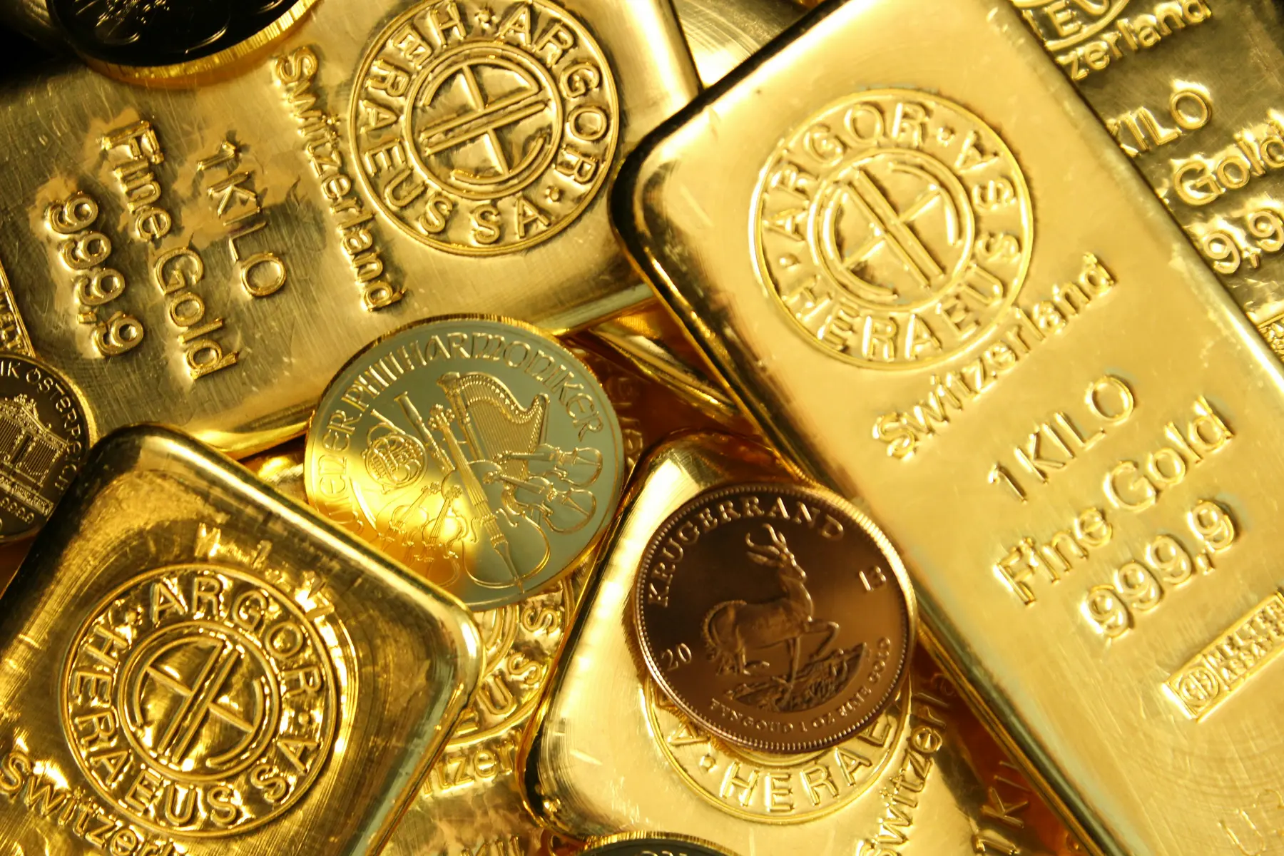 Stapel von Goldbarren und Goldmünzen