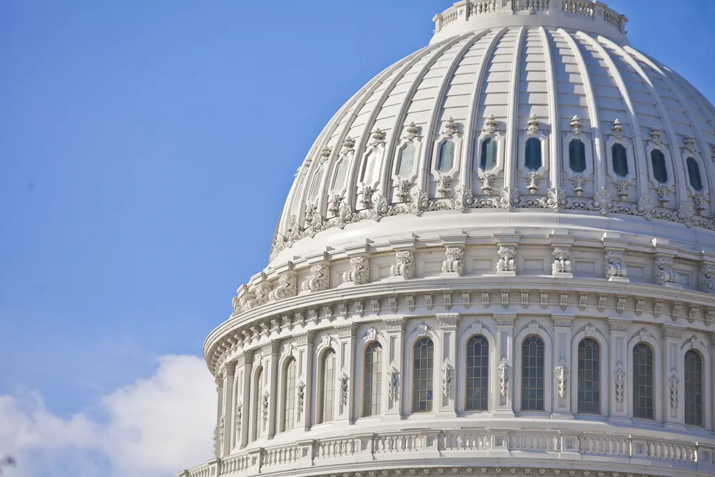 Nahaufnahme der weißen Kuppel des United States Capitol unter einem blauen Himmel.