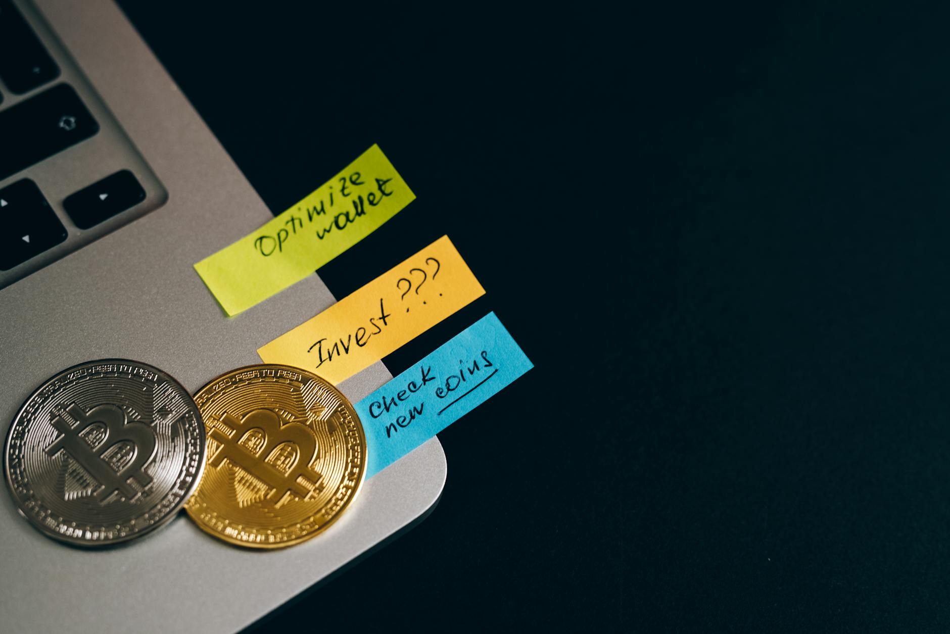 Laptop with Bitcoin coins and sticky notes reading 'Optimize wallet', 'Invest', 'Check new coins'.