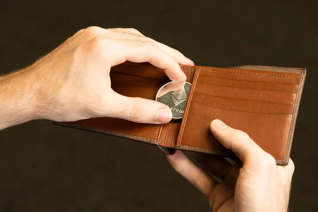 Een fysieke Ethereum-munt in een bruine lederen portemonnee.