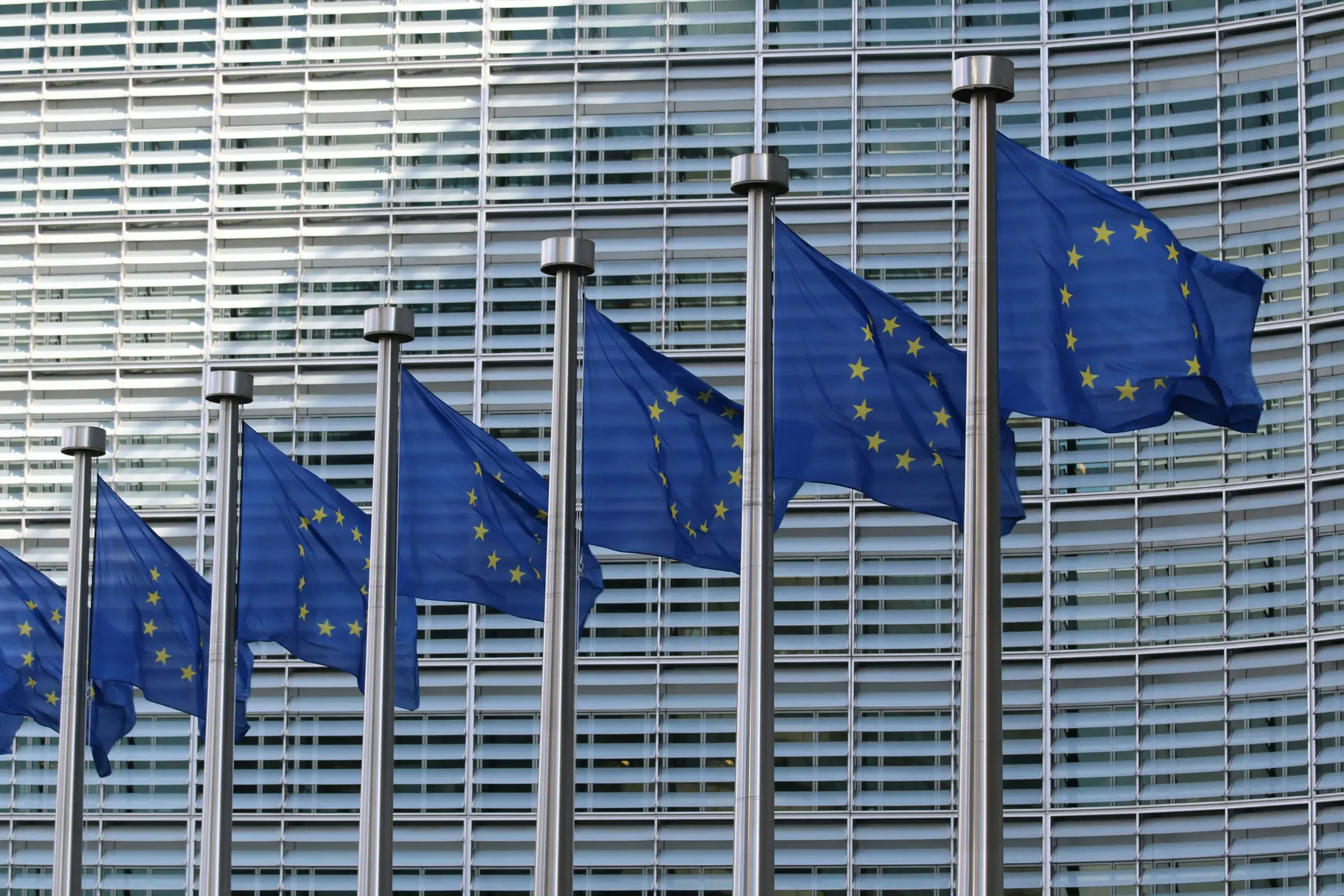Een rij vlaggen van de Europese Unie voor het Berlaymont-gebouw van de Europese Commissie.