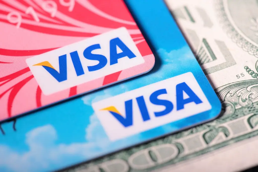 Close-up van twee Visa-betaalkaarten op een Amerikaanse dollarbiljet.