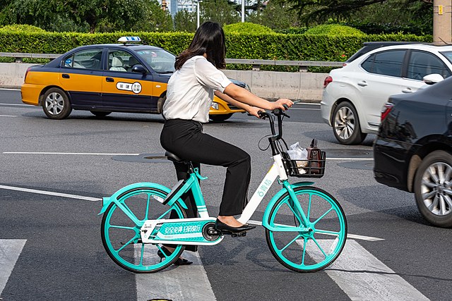 A woman rides a DiDi bicycle in China.
