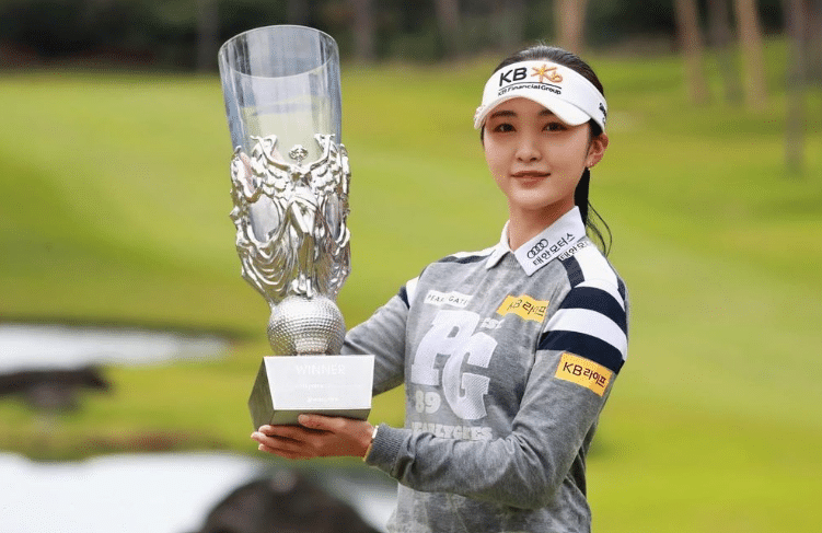 Golfer Lee Ye-won holds a golf trophy. 