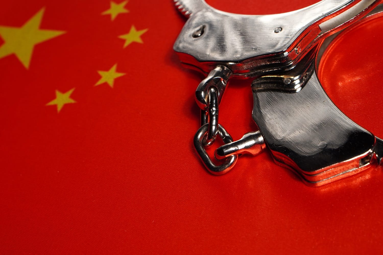 A pair of handcuffs rests on the flag of China.