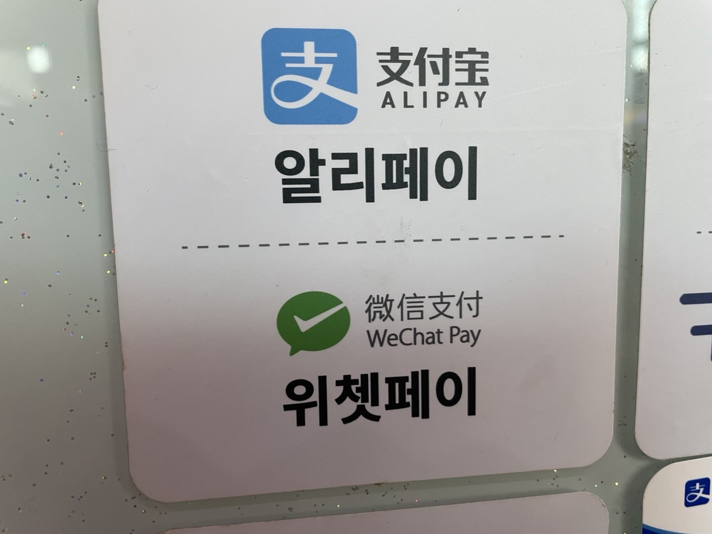 A sign on a store in Seoul, South Korea, shows that Alipay and WeChat Pay are accepted.