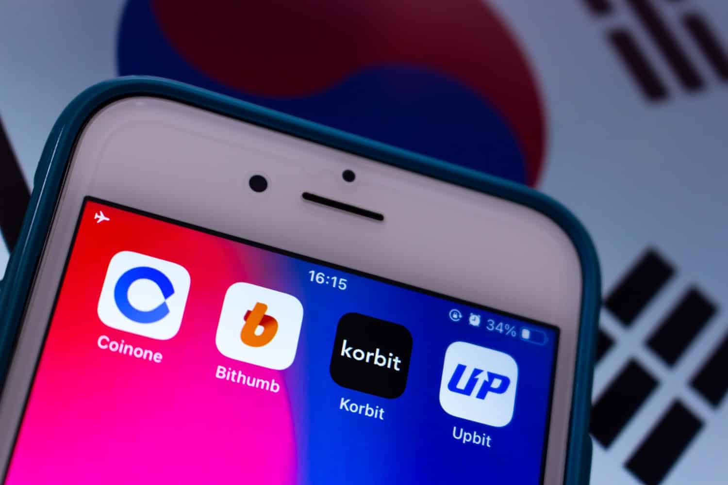 The apps of Coinone, Bithumb, Korbit, and Upbit on an iPhone screen with the South Korean flag in the background.