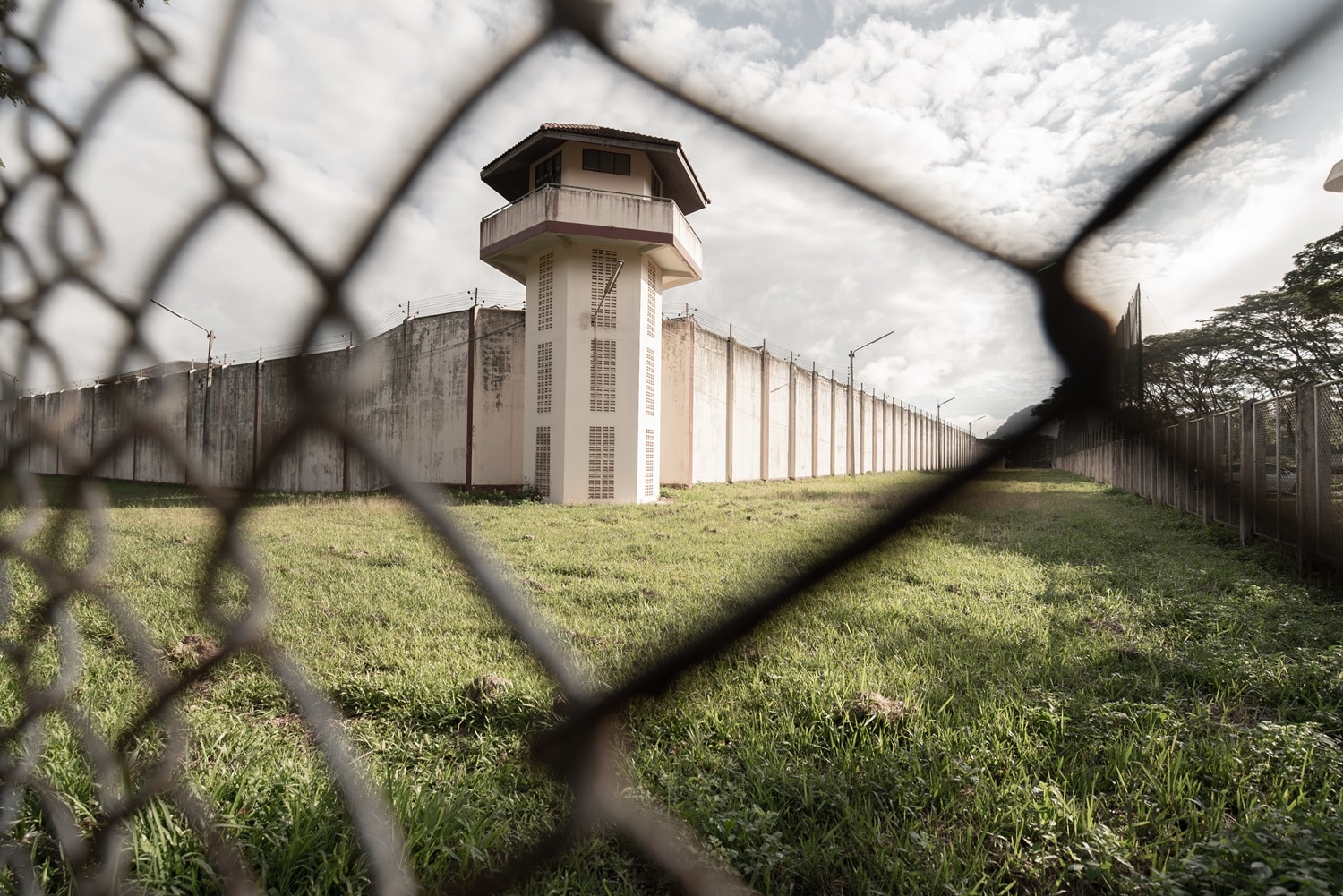 A prison photographed from behind its wire fence.