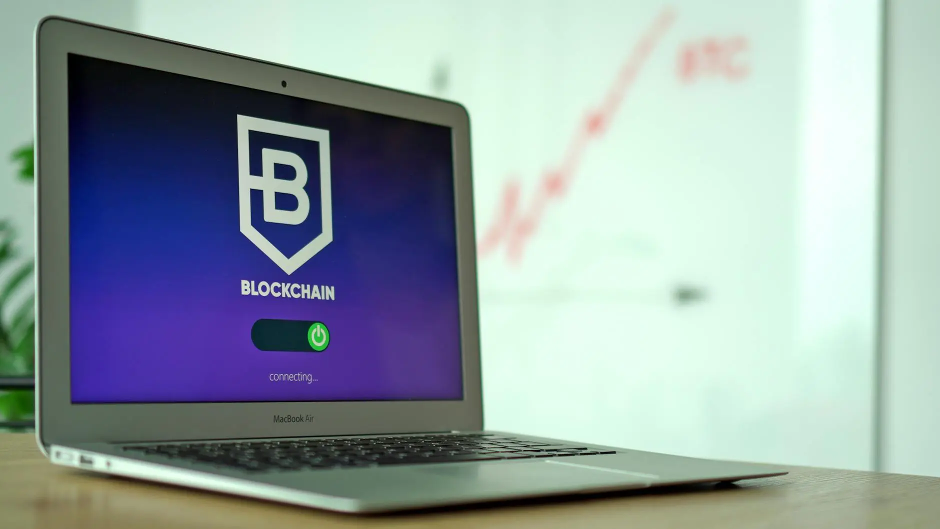 Laptop displaying a blockchain login screen with connecting status.