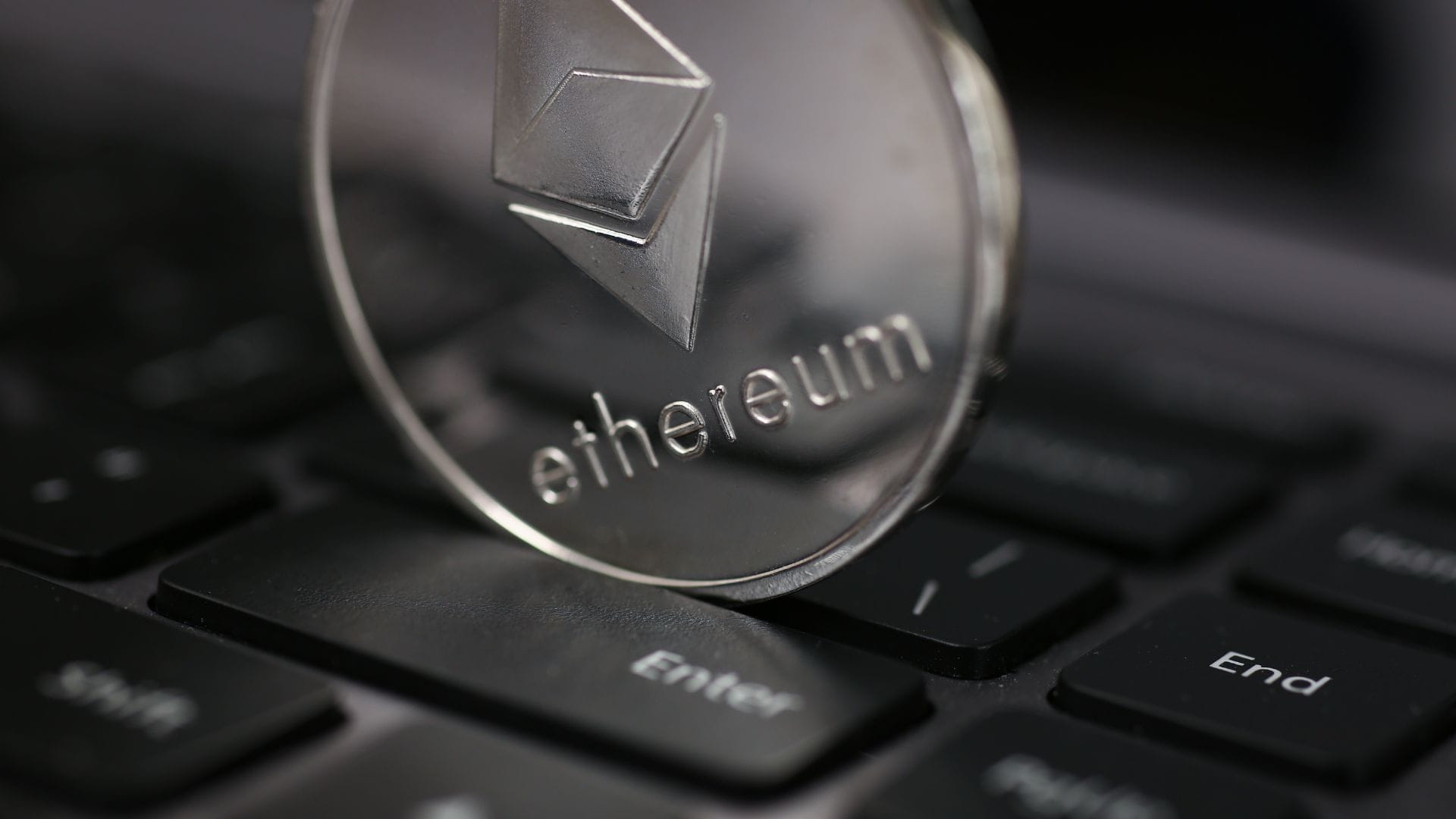 Ethereum-kolikko tietokoneen näppäimistön päällä.