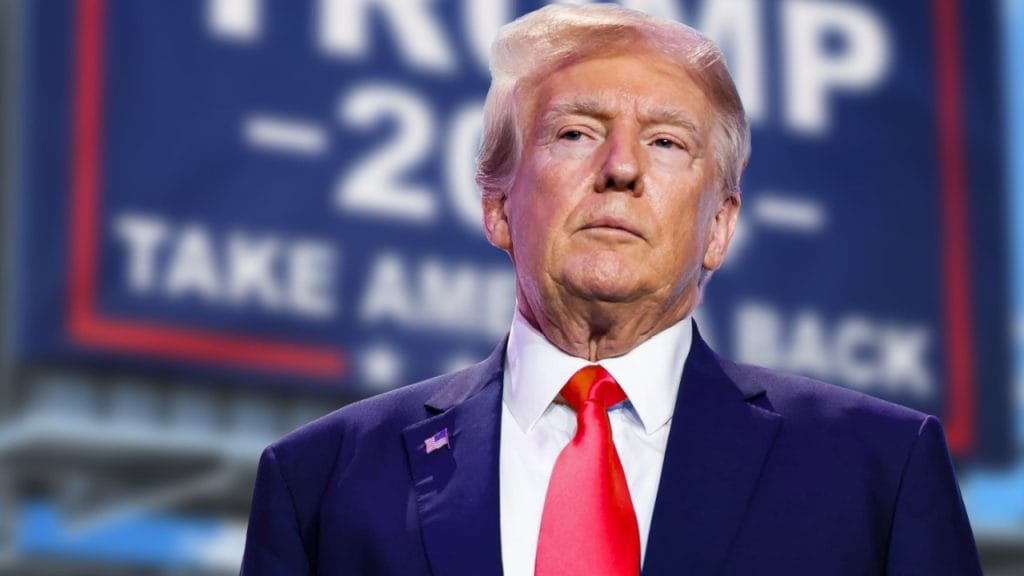 Donald Trump seisoo vaalitapahtumassa Trump-kyltin edessä.