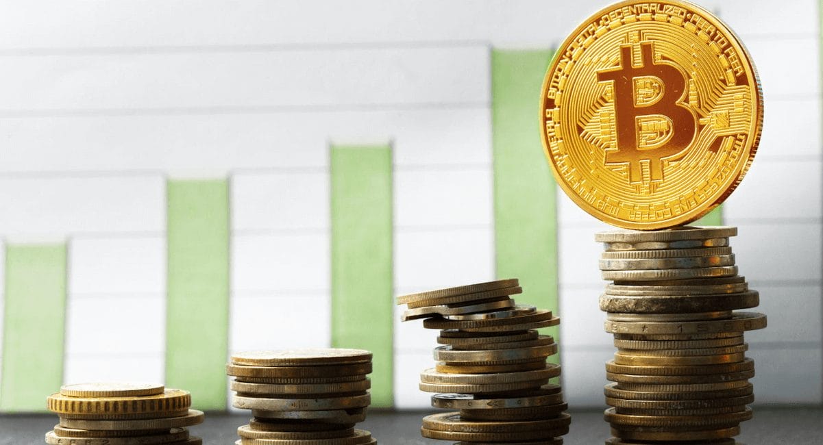 مجسّمات معدنيّة لعملة بيتكوين على خلفية أعمدة بيانية تصاعدية